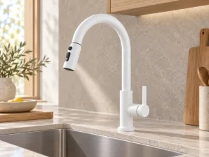 Pull-out kitchen faucet scene White pull-out kitchen faucet beside a stainless steel sink and pale stone counter